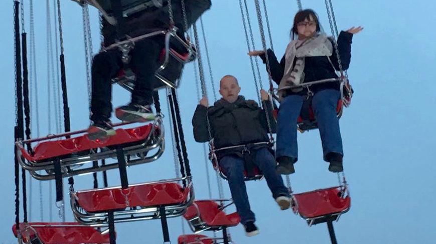 Sam and Megan on swings at Winter Wonderland.